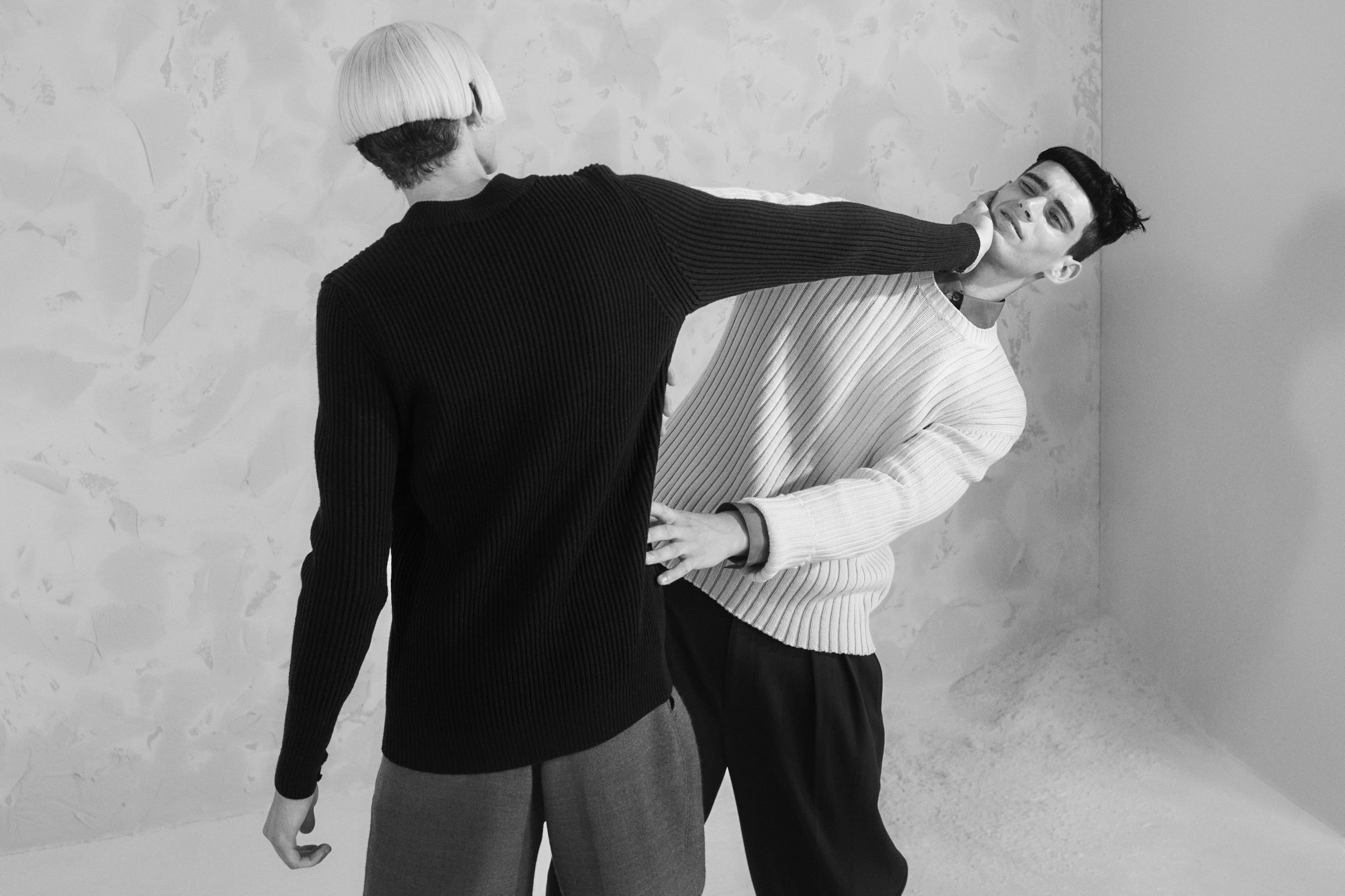 From left: Frye wears sweater by Willy Chavarria. Pants by Nanushka. Hughes wears vintage sweater by Helmut Lang from the David Casavant Archive. Shirt by Ouer. Pants by Lemaire.